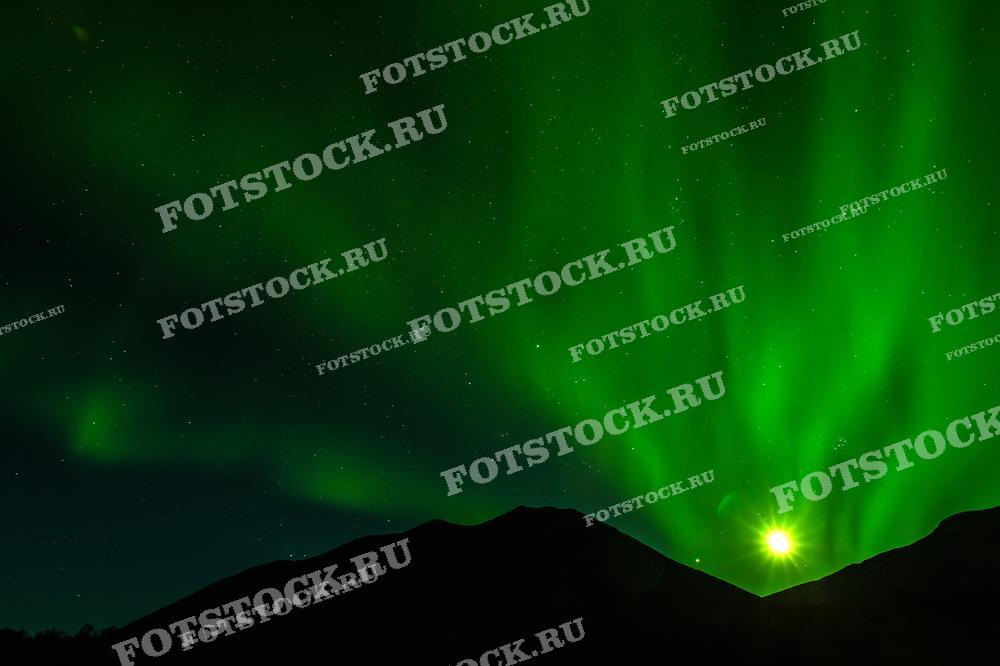 На изображении захватывающее зрелище северного сияния в Хибинах (Мурманская область). Яркая звезда или планета светится внизу справа, добавляя магии к этому великолепному природному феномену.